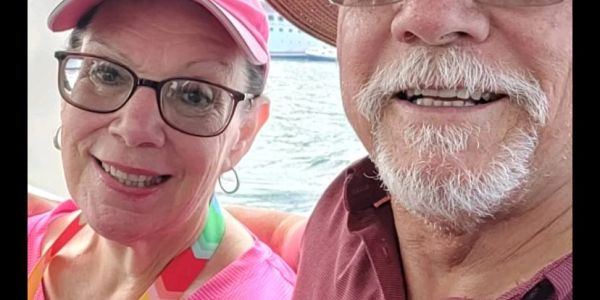 Smiling older couple taking a selfie by the water.