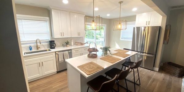 Bright modern kitchen with white cabinets and island seating.