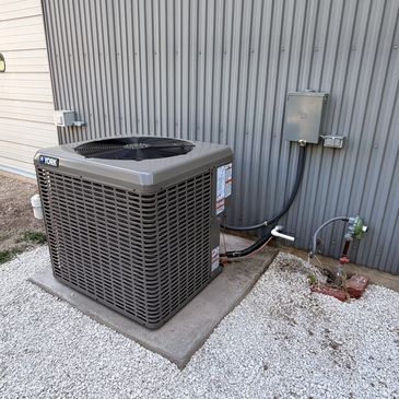 Outdoor York air conditioning unit installed on concrete pad.