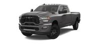 A black RAM pickup truck with a bold front grille and rugged tires.