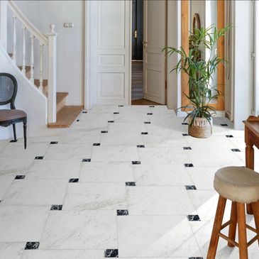 Bright hallway with white marble floor and stairs.