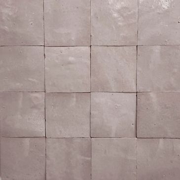 Wall made of square beige tiles.