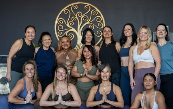 A group of women posing together in workout clothes.