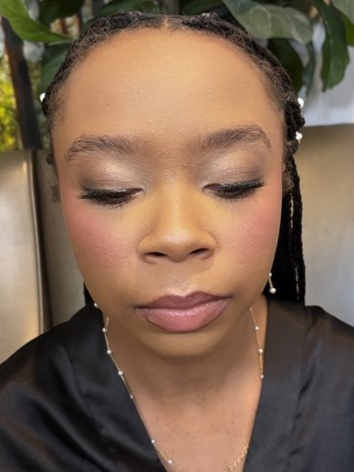 Close-up of a woman with elegant makeup and braided hair.