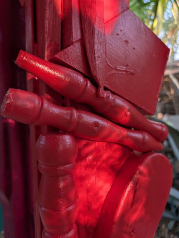 Close-up of red painted wooden object outdoors.