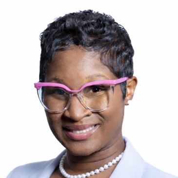 Smiling woman with short hair and pink glasses.