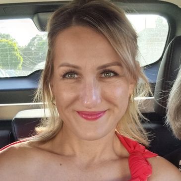 Smiling woman with light hair in a car.