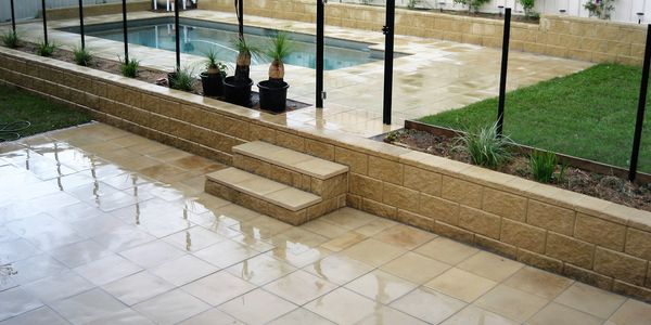 Pool surrounded by landscaped area inciuding paving, pool fence and garden