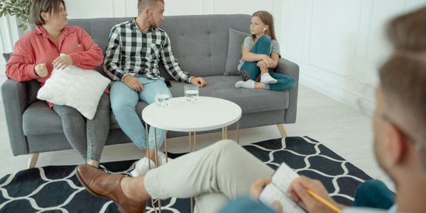 A family discussing with a therapist in a counseling session.