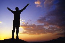 Photo of a man silhouetted against a sunset