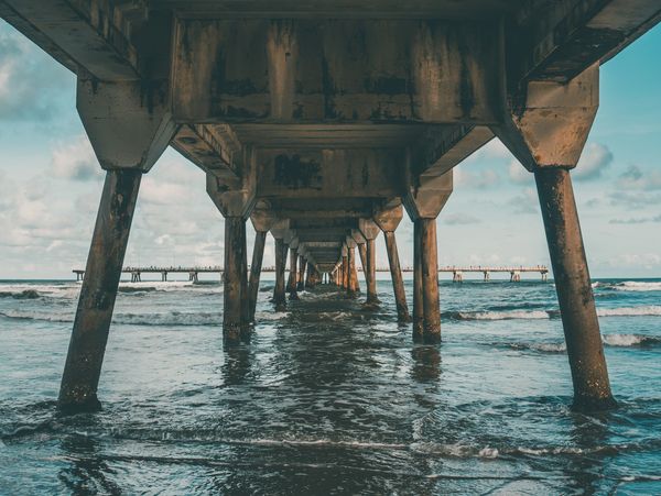Вид під мостом над морем з хвилями.
