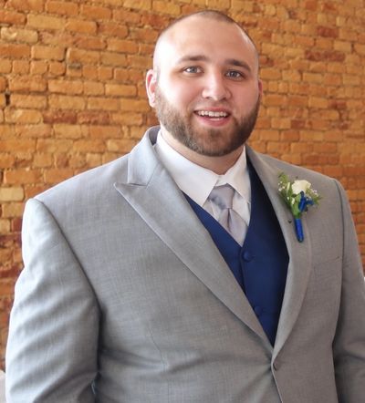 Man in gray suit smiling.