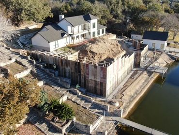 Aerial view of retainer wall between house and lake.