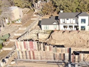 Aerial view of retainer wall between house and lake.