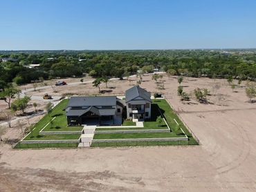 Aerial view of a modern home with a lake. 