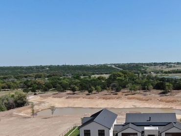 Aerial view of a modern home with a lake. 