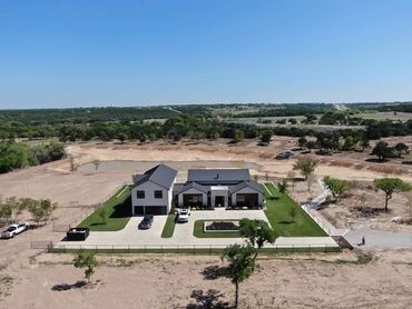 Aerial view of a modern home with a lake. 