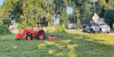 Kubota tractor mowing land