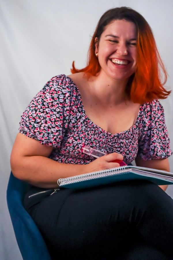 Coach with oversized pen and notebook laughing in conversation