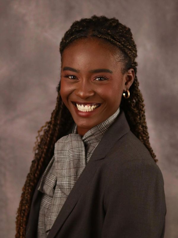 Young woman smiling in professional attire.