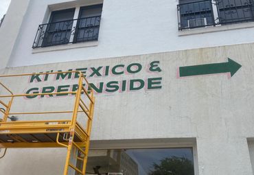 Wall sign on stucco, photographed work in progress.