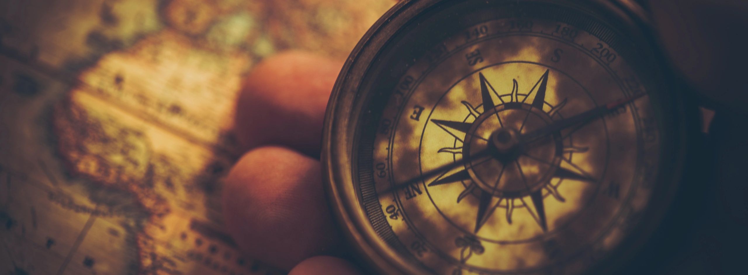 Stack of books next to pencils in a holder and a camera.
