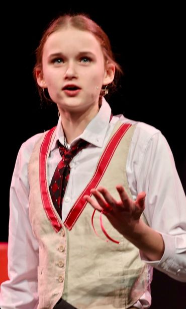 Young actor delivering a passionate monologue on stage.