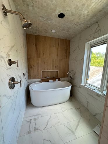 Modern bathroom with freestanding tub and wood accent wall.