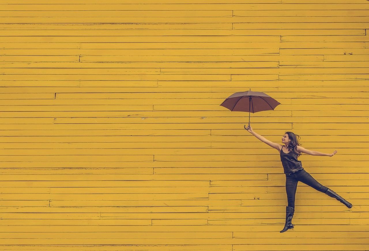 Woman with umbrella floating on wall.