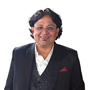 Smiling man in formal attire with glasses and wavy hair.