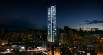 A tall, illuminated skyscraper at night in a cityscape.