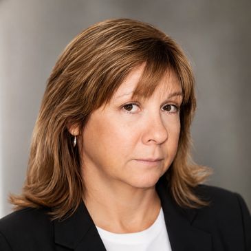 Professional headshot of a woman with light brown hair.