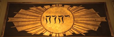 Ancient Hebrew text on a radiant golden sunburst plaque.