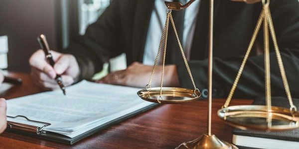 Legal consultation with scales of justice and contract signing.