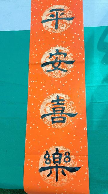Traditional Chinese calligraphy on red paper with gold patterns.
