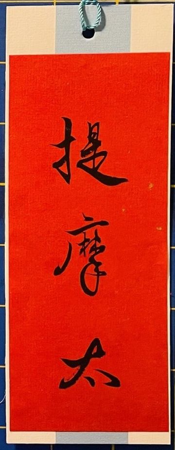 Red paper with Chinese calligraphy characters in black ink.