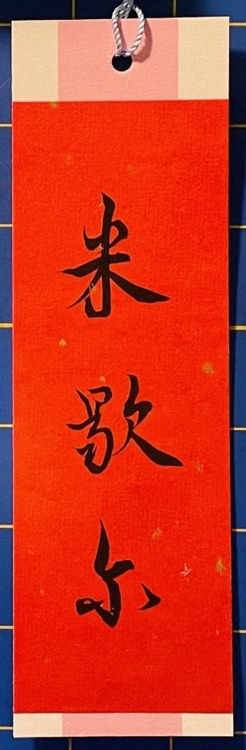 Red Chinese calligraphy scroll with three black characters.