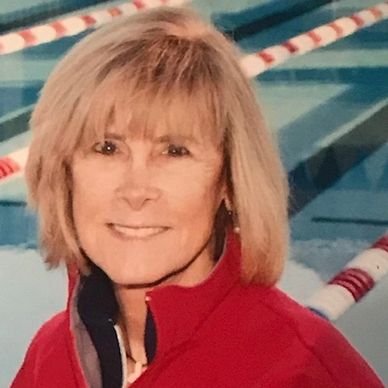 Smiling woman near a swimming pool.