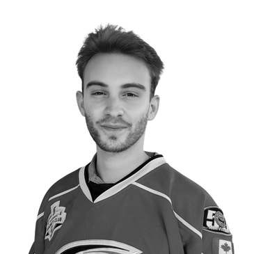 Photo of Andrew Marrone, physiotherapist, in front of a clinic window, wearing a hockey jersey