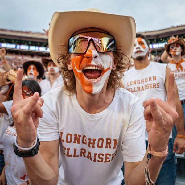 Fan with face paint and cowboy hat at a sports event.