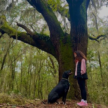 Trainer and her dog in the woods 