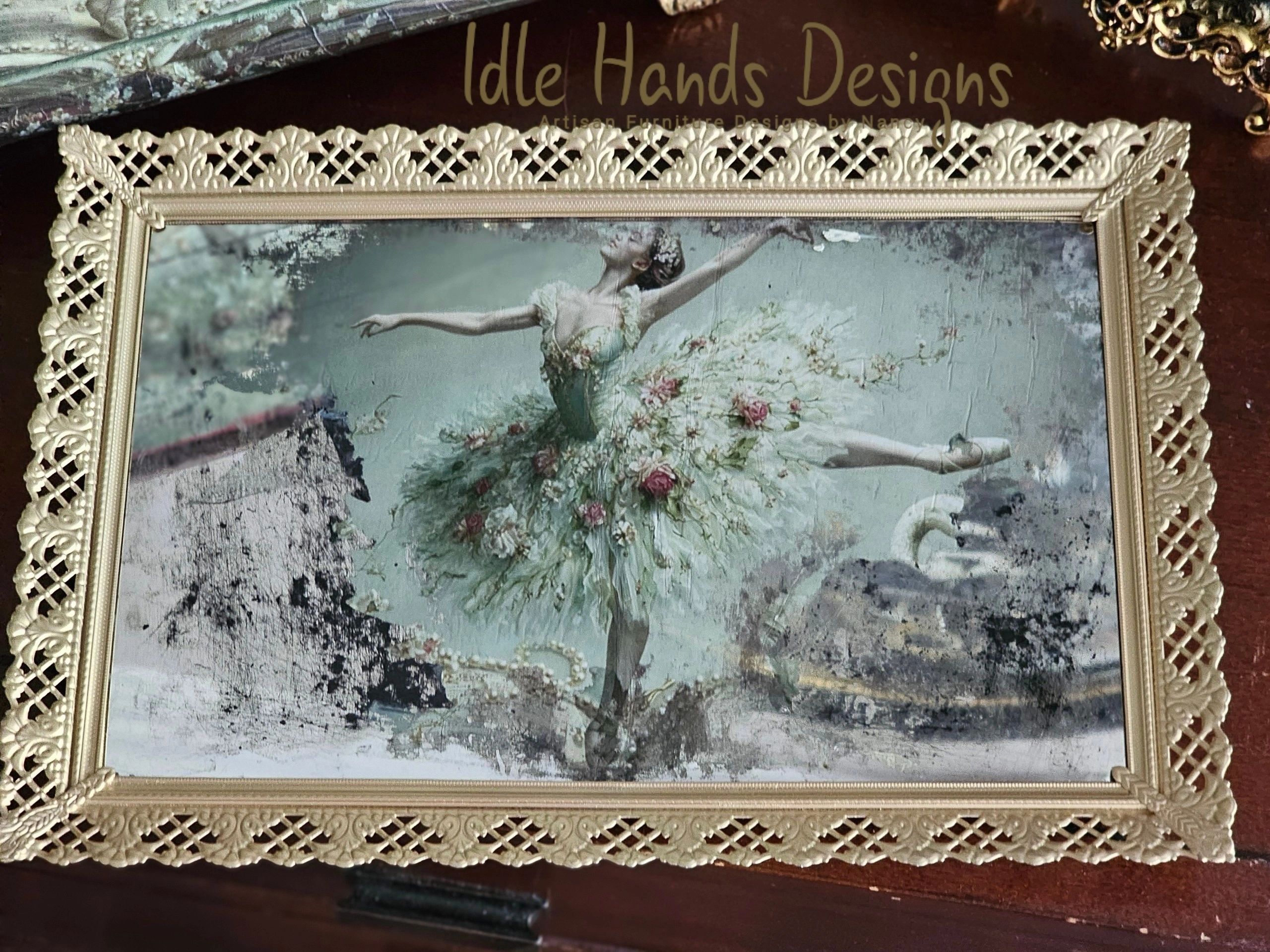 Ornate framed painting of a ballerina in a floral tutu.