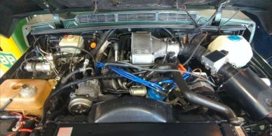 Detailed view of a car engine bay with various components and wiring.
