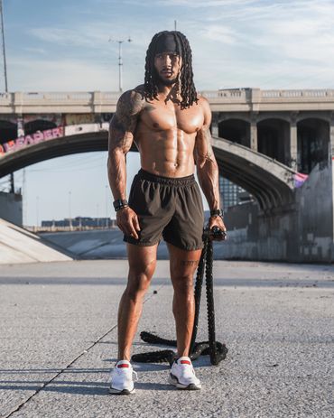 male fitness athlete standing with battle ropes in the LA River in Los Angeles