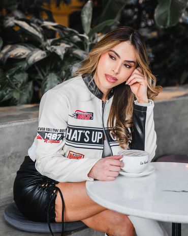 Lifestyle fashion photo of a stylish woman enjoying coffee at a modern café.