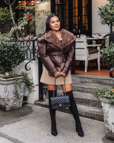 Chic fashion photography of a stylish woman in fall outfit posing confidently outdoors.