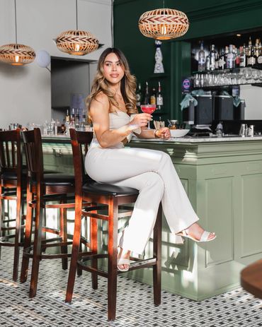 Lifestyle photography of a stylish woman enjoying a cocktail at a chic modern bar