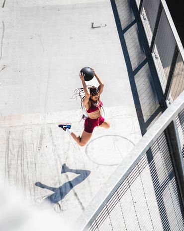 female fitness athlete performing ball slam on 7th Street bridge in Los Angeles