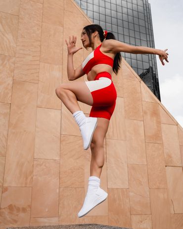 fitness photography of a gym girl performing functional athletic exercise outside