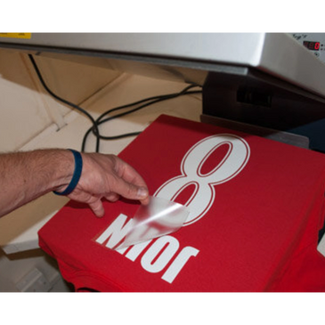 Applying heat transfer vinyl to a red shirt with the name "John" and number "8".
